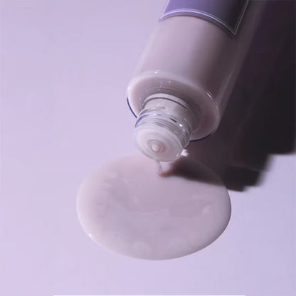 Close-up of a tube of cream with a visible cream smear on a light purple background