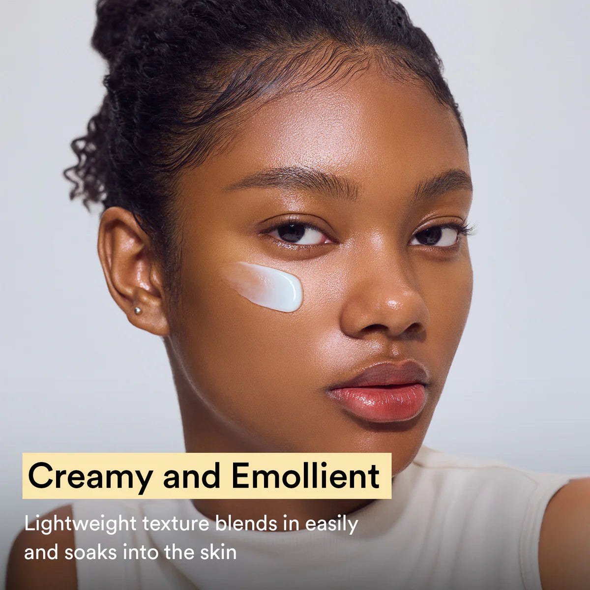 Woman with a product sample on her face, text about creaminess and emolliency.