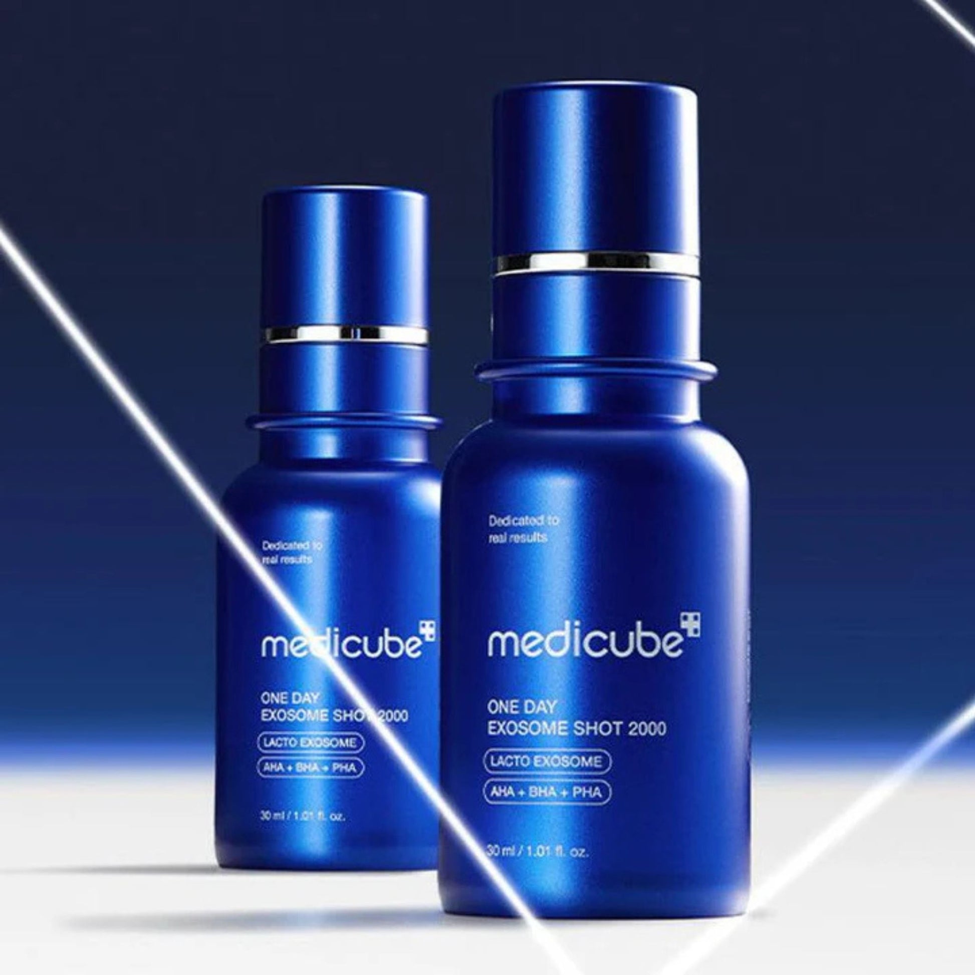 Two blue bottles of Medicube skincare product on a gradient background