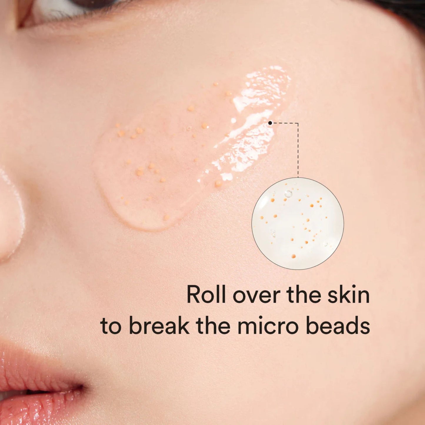 Close-up of skin with a product application and text instructing to roll over the skin to break micro beads.