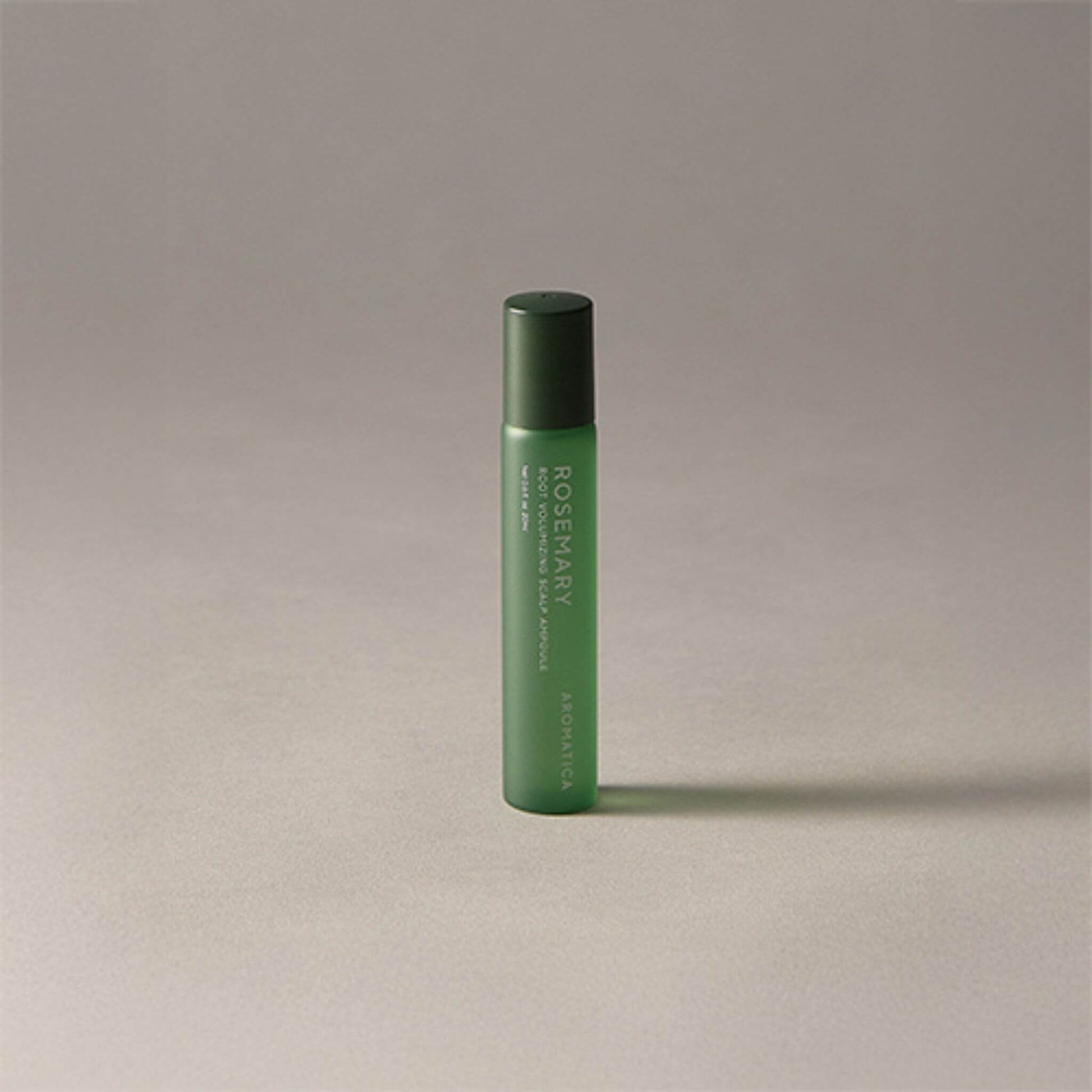 Green cylindrical bottle with text on a beige background