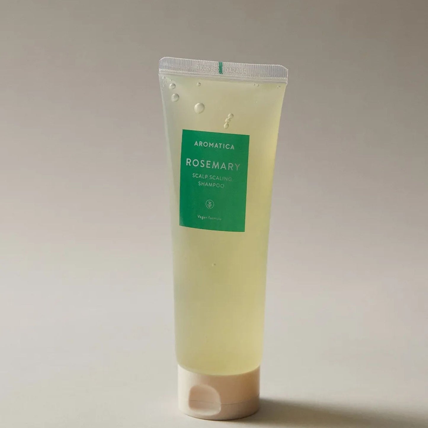 Tube of Aromatica Rosemary Scalp Scrub on a beige background
