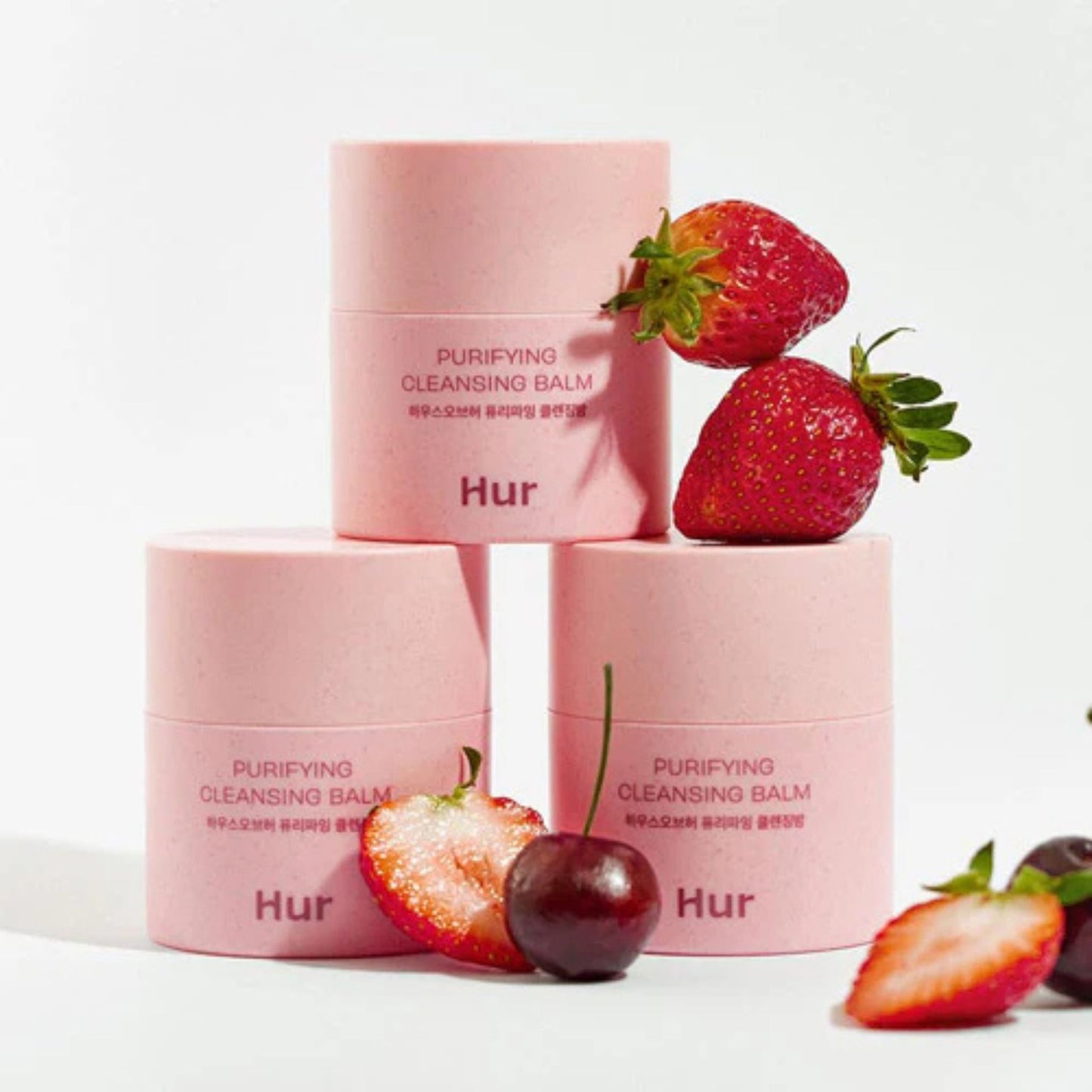 Pink skincare products with strawberries on a white background