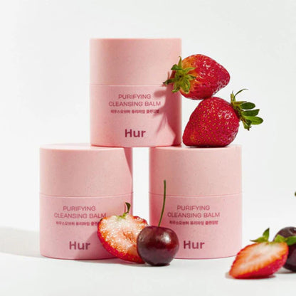 Pink skincare products with strawberries on a white background