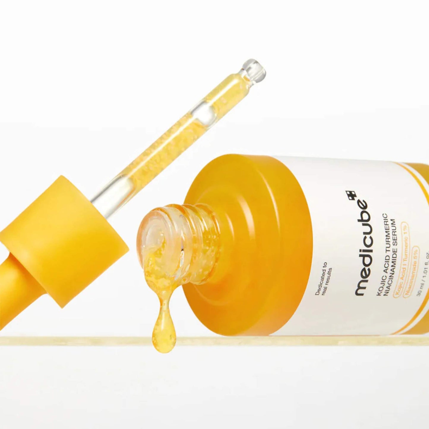 Medicube bottle with yellow serum and dropper on a white background