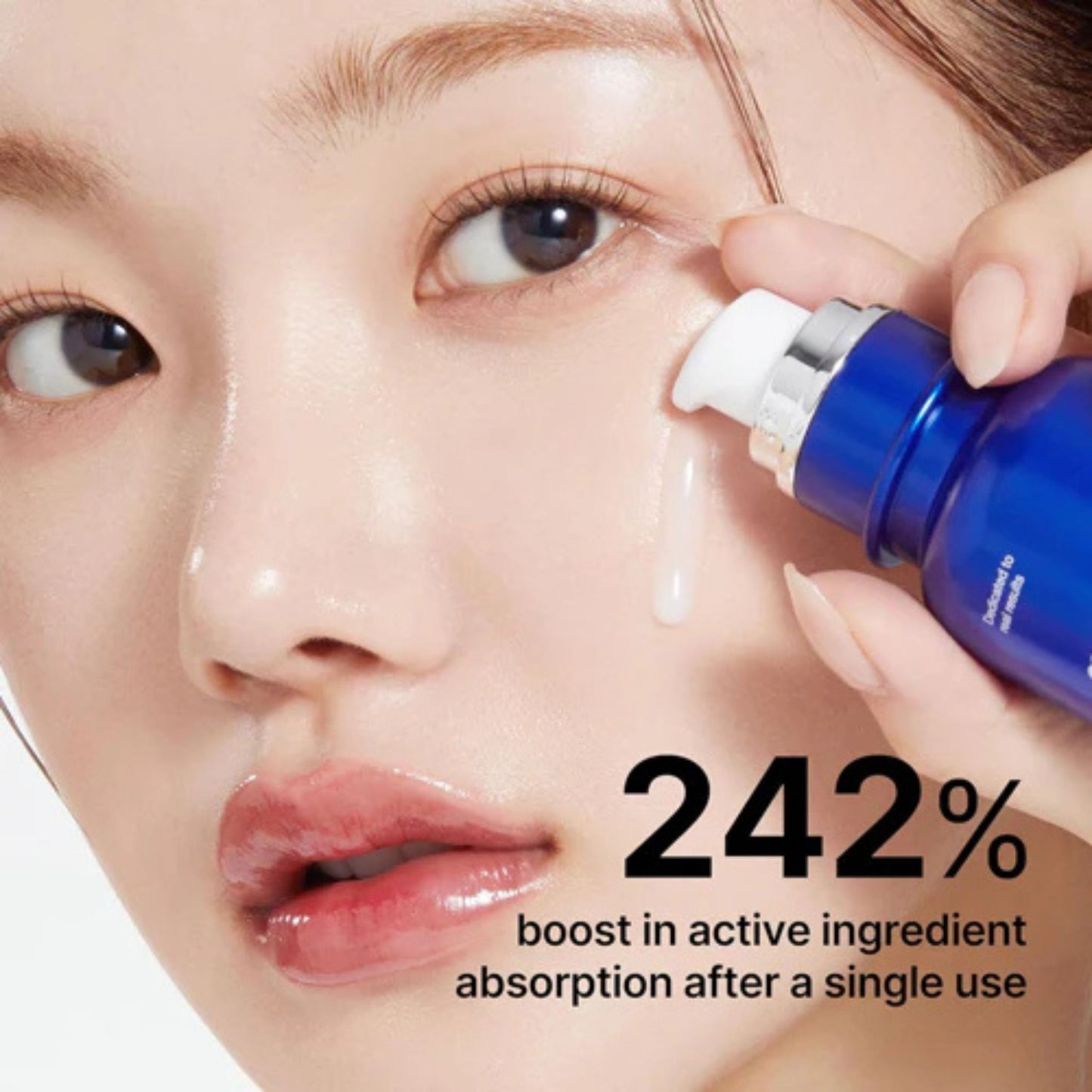 Woman applying a blue skincare serum to her face with text about active ingredient absorption.