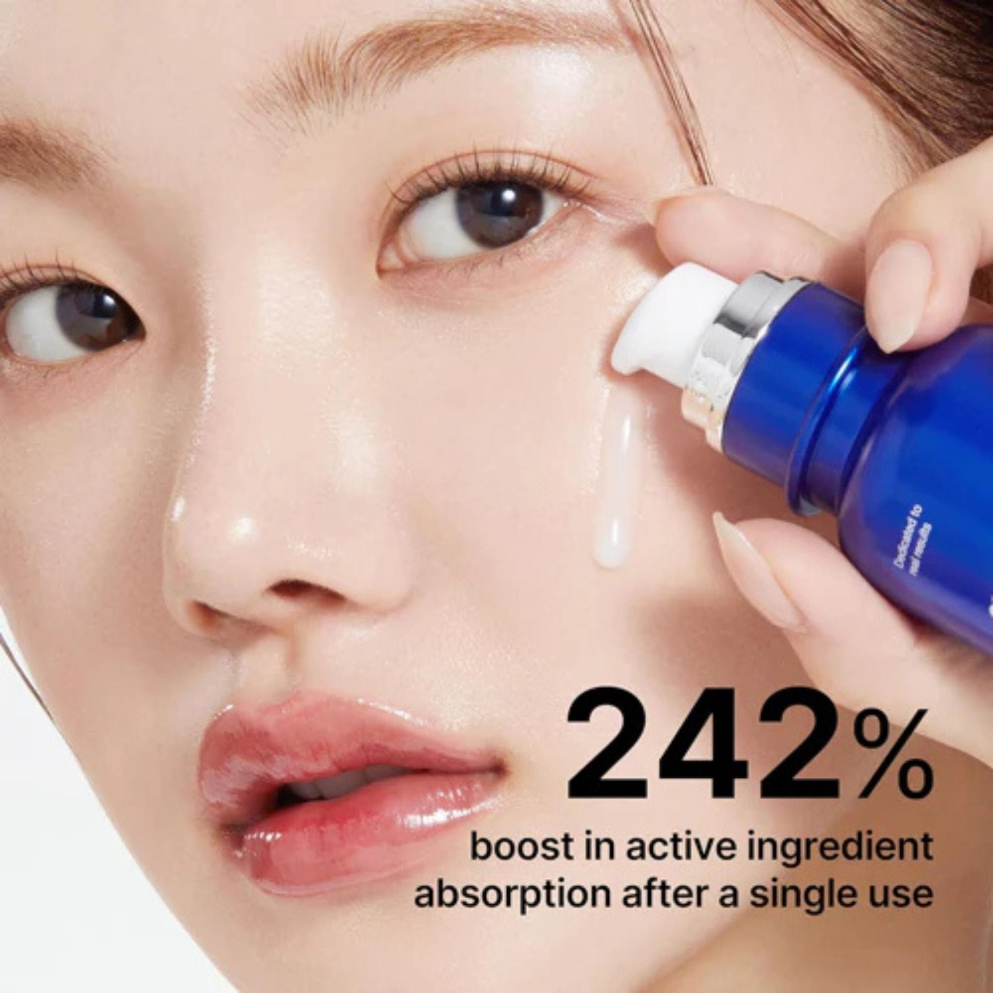 Woman applying a blue skincare serum to her face with text about active ingredient absorption.