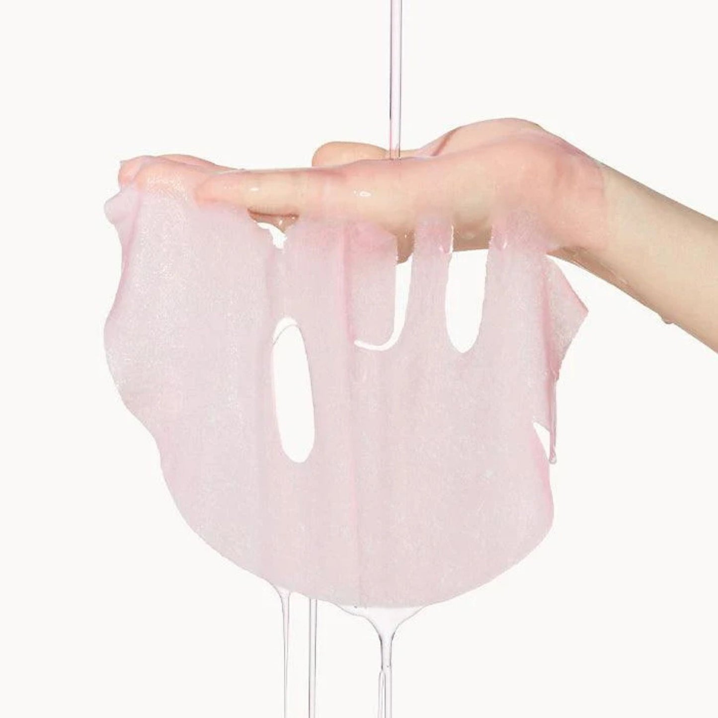 Hand holding a pink silicone glove against a white background