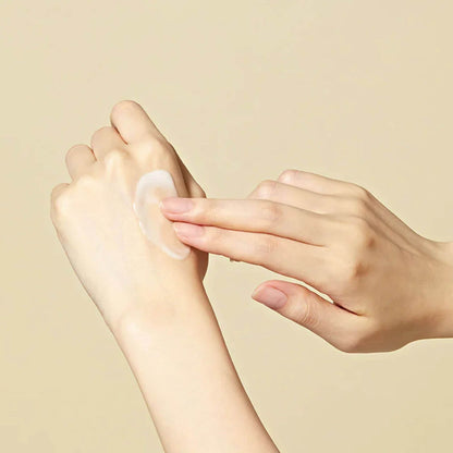 Person applying a transparent patch to their foot against a beige background