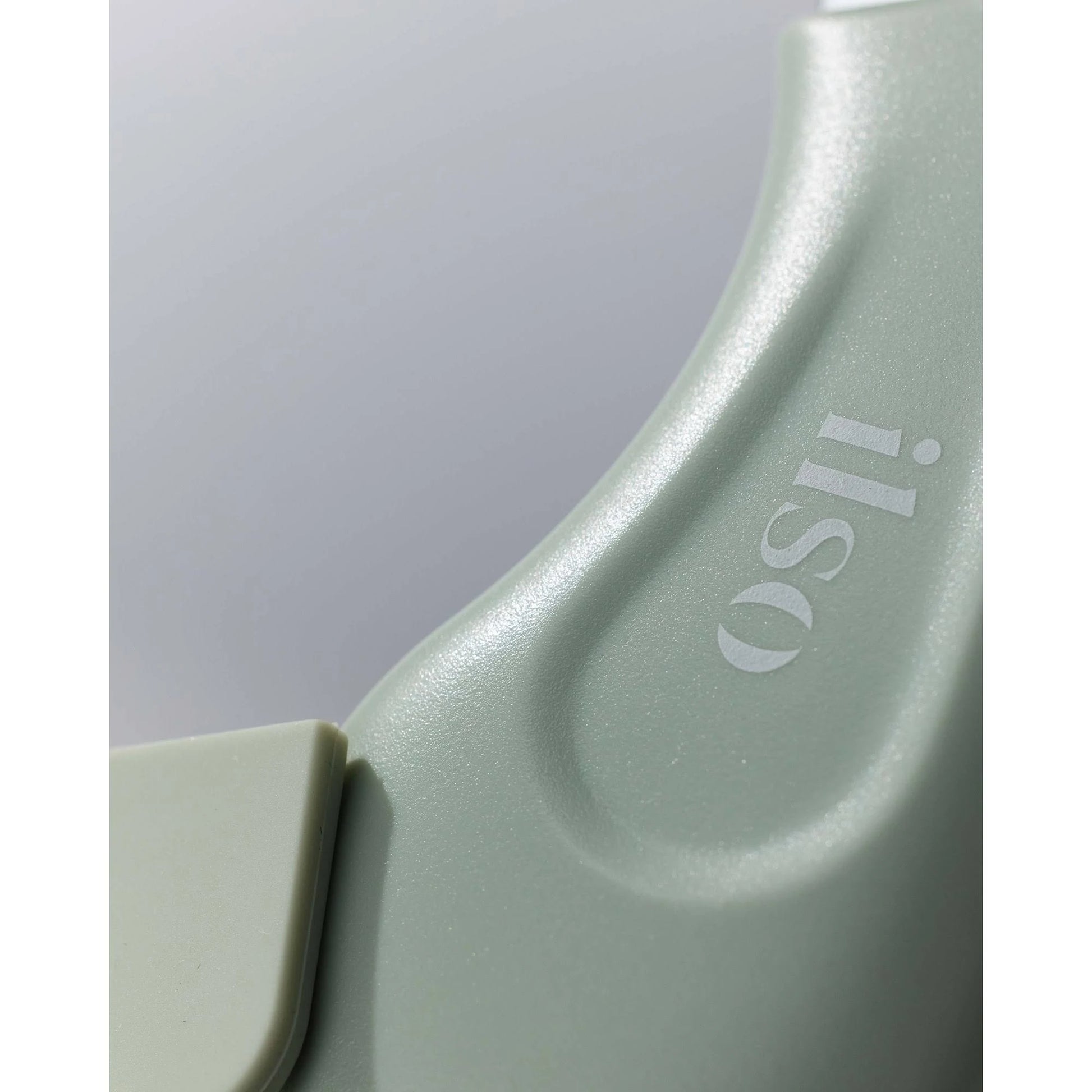 Close-up of a light green silicone tool with 'iliss' branding on a white background