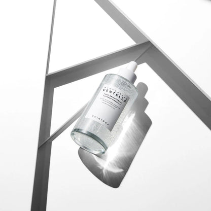 Skincare bottle with 'The Centella' label on a geometric metal frame background