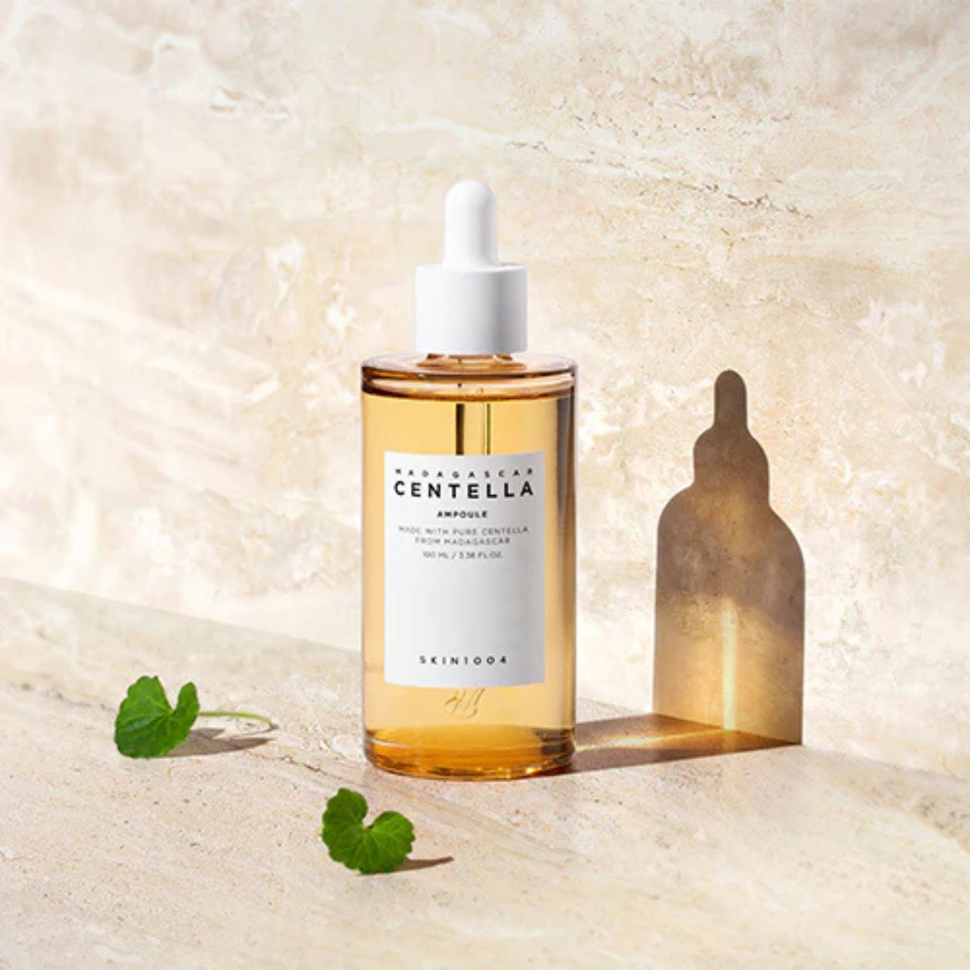 Skincare bottle with dropper on a textured beige background