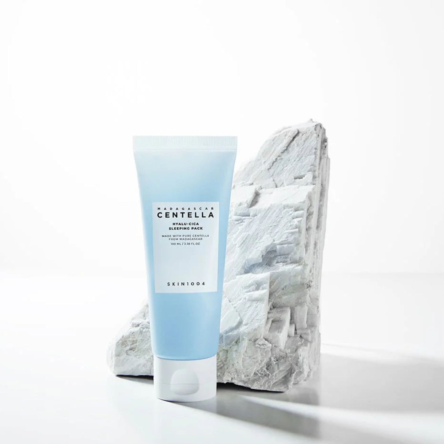 Skincare tube labeled 'Nurture Centella' on a white background with a stone-like texture.