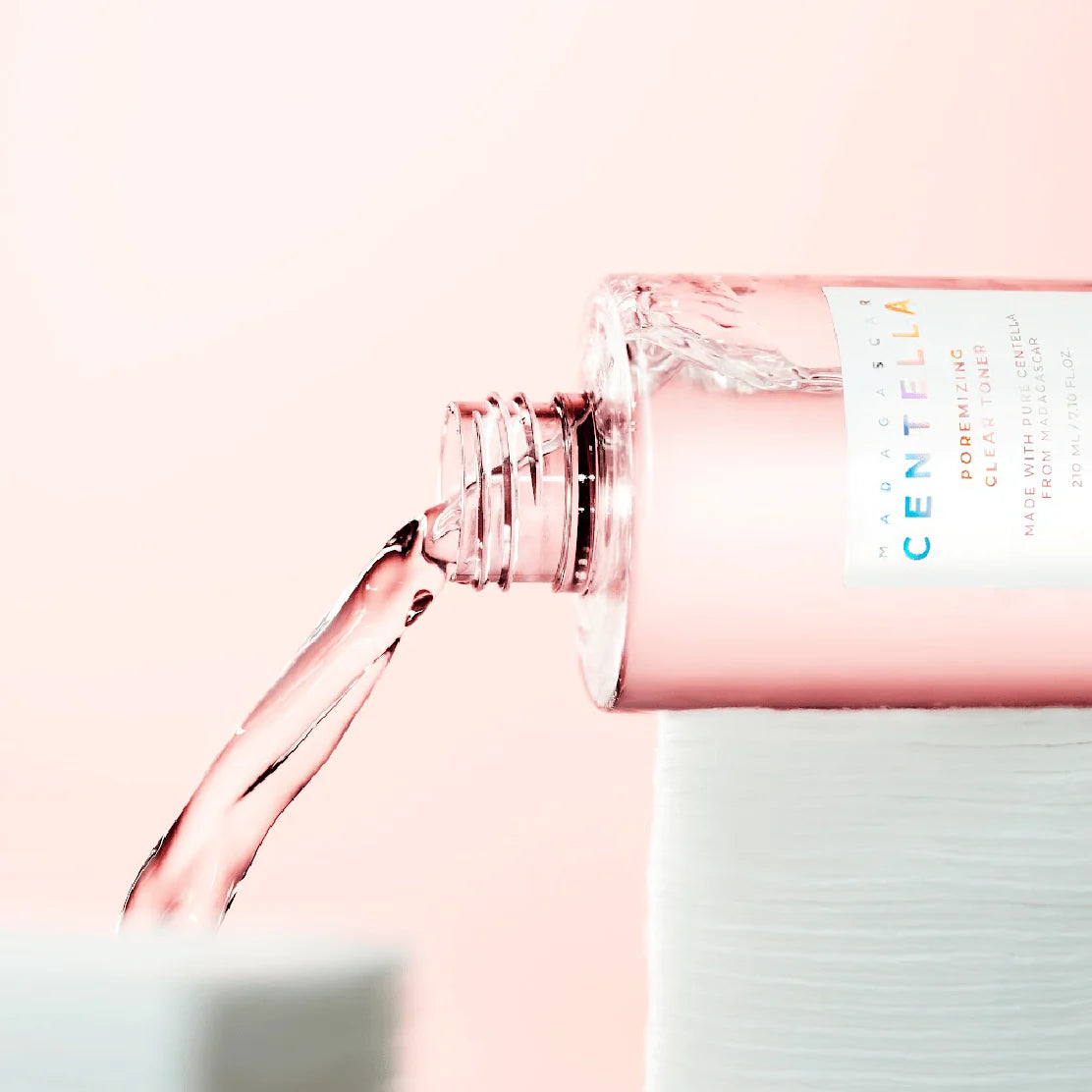 Bottle of Centella water with a pink cap on a light pink background