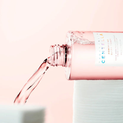 Bottle of Centella water with a pink cap on a light pink background