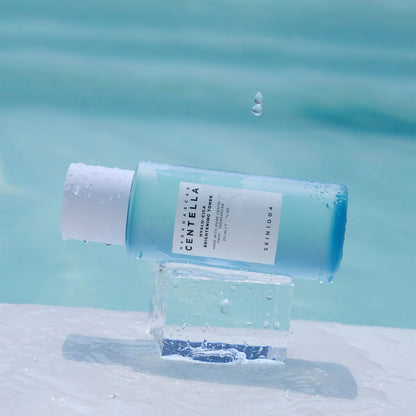 Skincare bottle with a droplet on a water surface