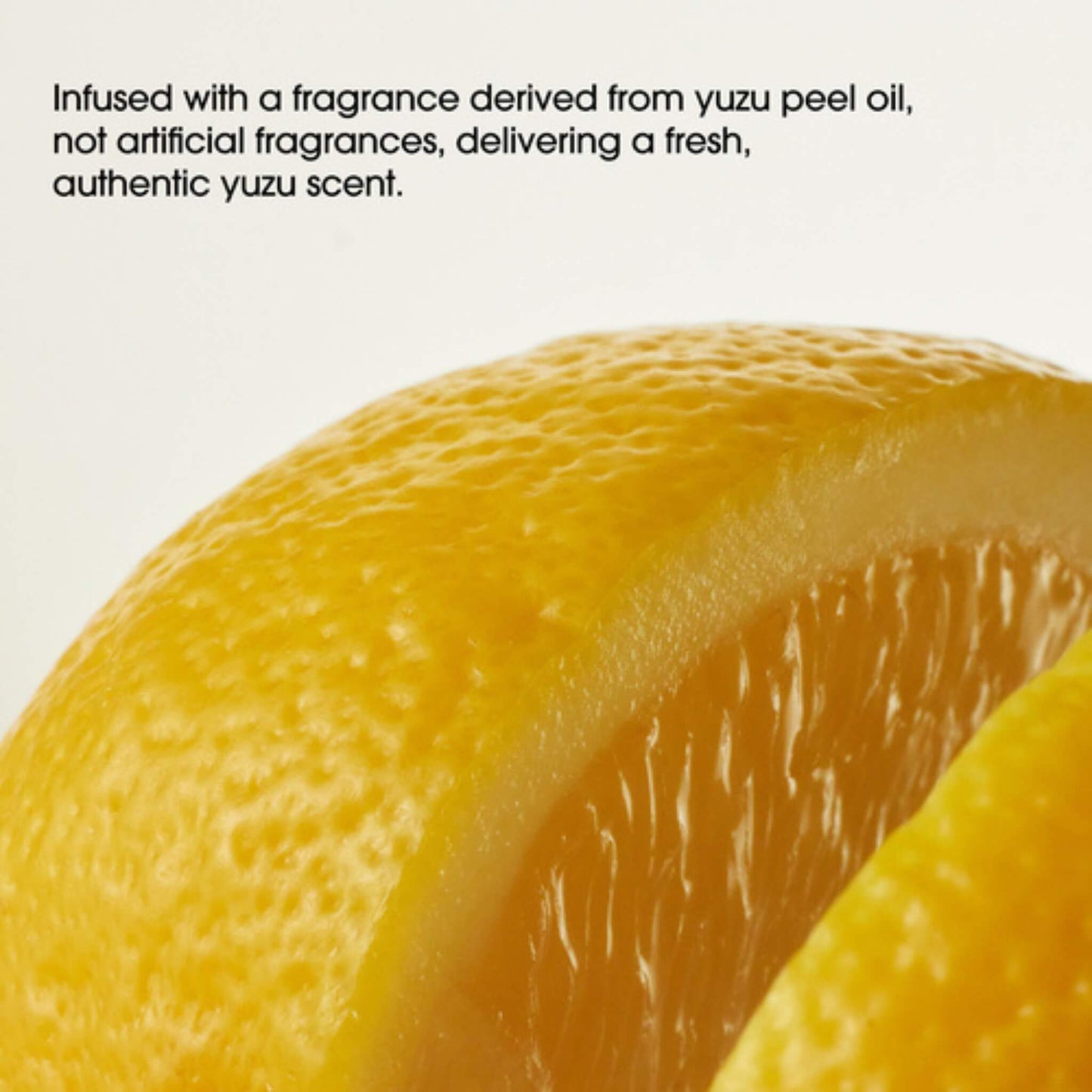 Close-up of a sliced yuzu fruit with text about its fragrance.