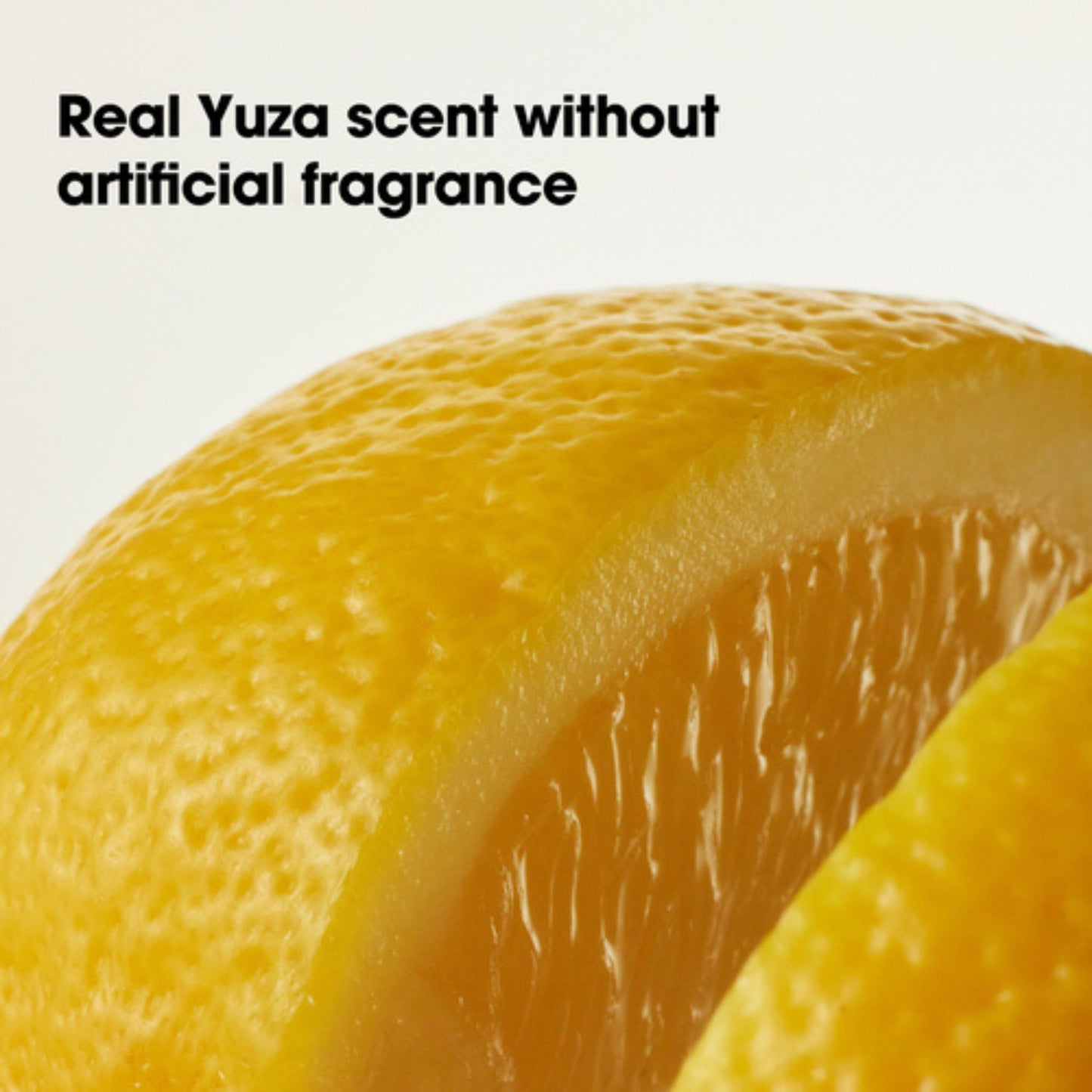 Close-up of a sliced orange with text about real Yuza scent.