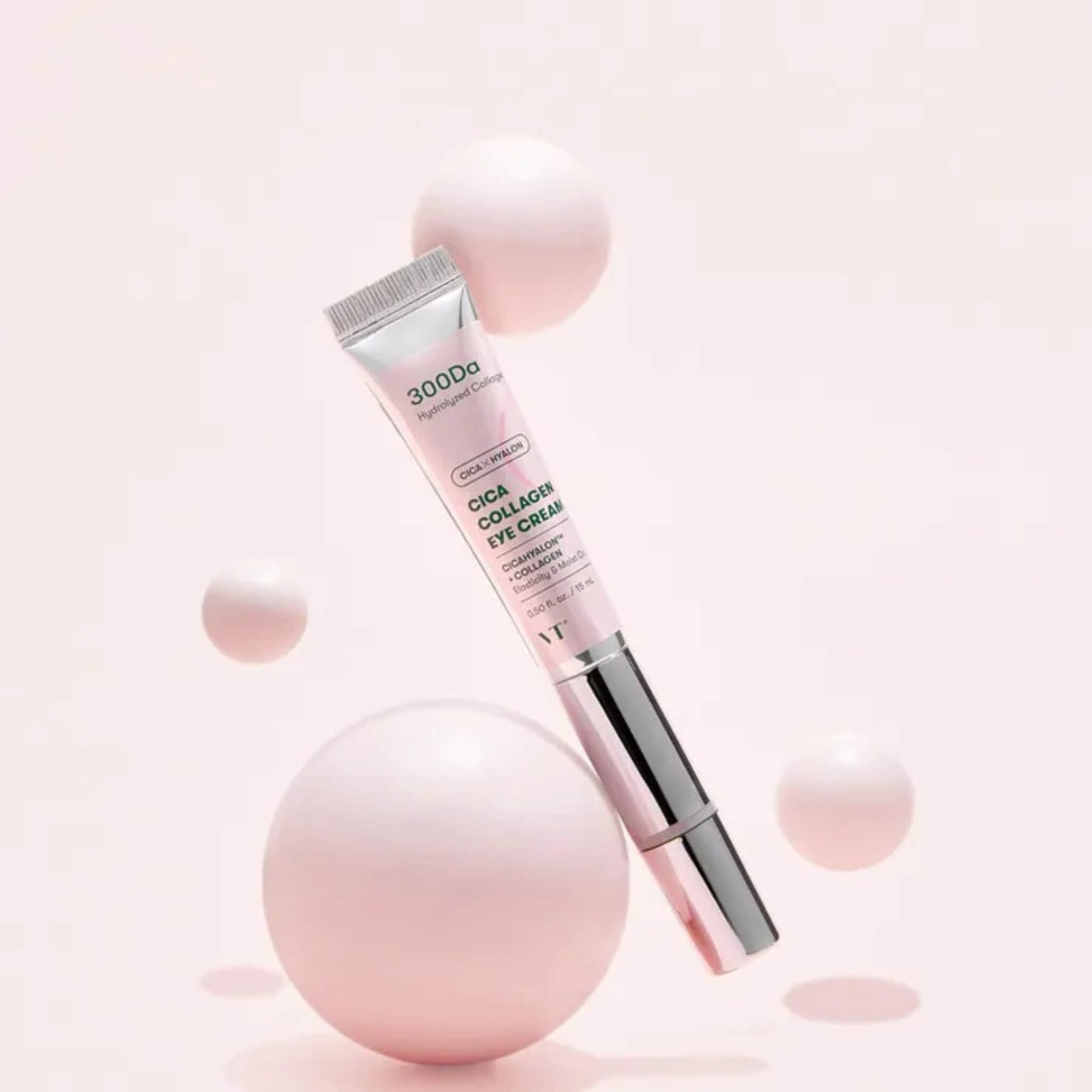 Eye cream tube with pink spheres on a light pink background